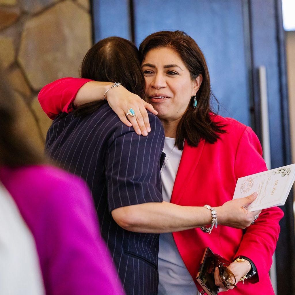 Two women embrace at the HCISD retiree dinner